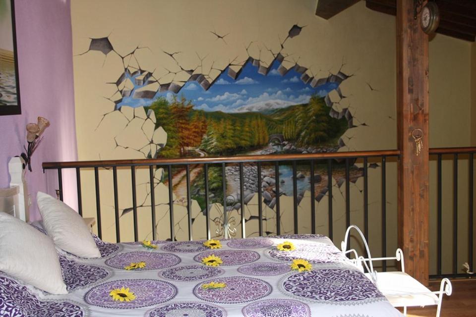 1 dormitorio con 1 cama con una pintura en la pared en Casa Rural Rosa Magica, en Lancharejo
