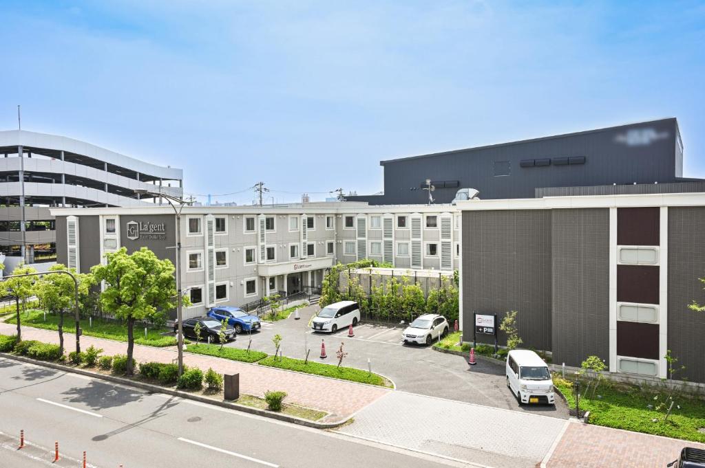 a large building with cars parked in a parking lot at La'gent Hotel Osaka Bay in Osaka