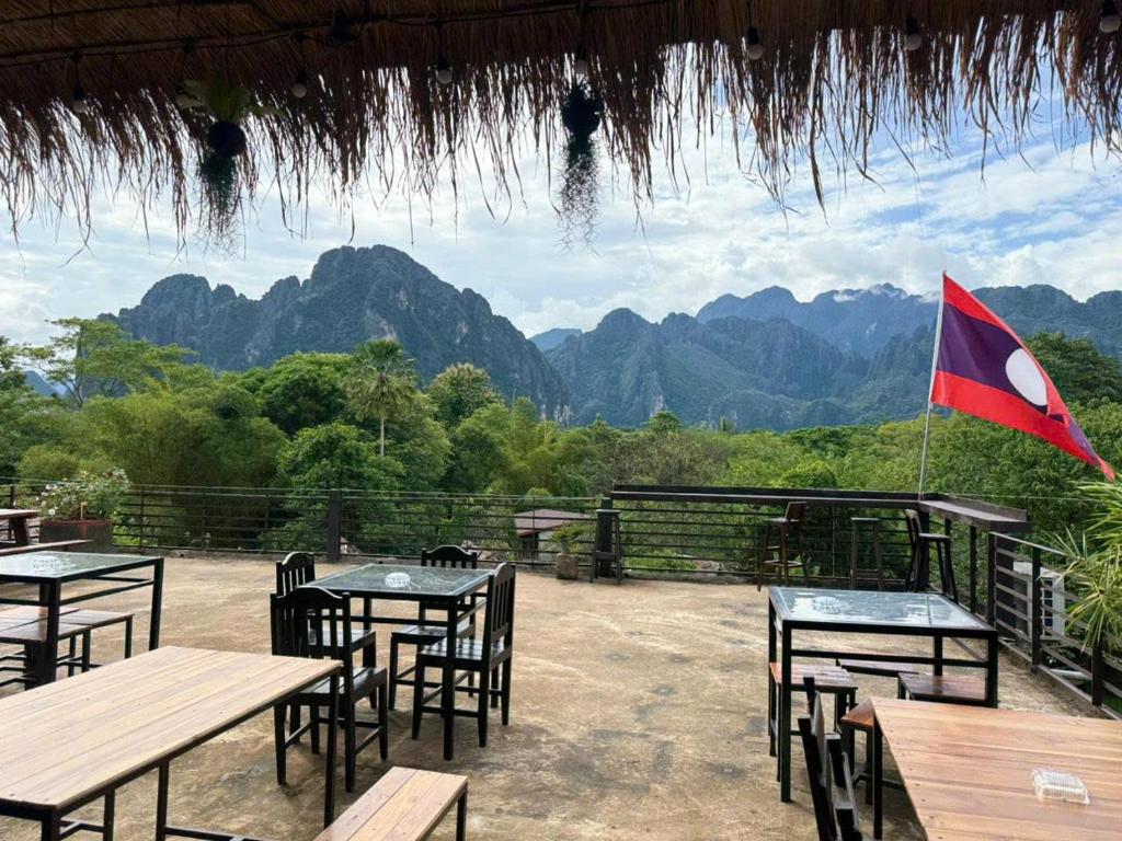 a flag on top of tables with mountains in the background at Vang Vieng Ban Lao Guesthouse in Vang Vieng