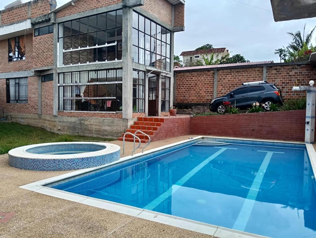 a swimming pool in front of a house at Casa Finca de verano in Chachagüí