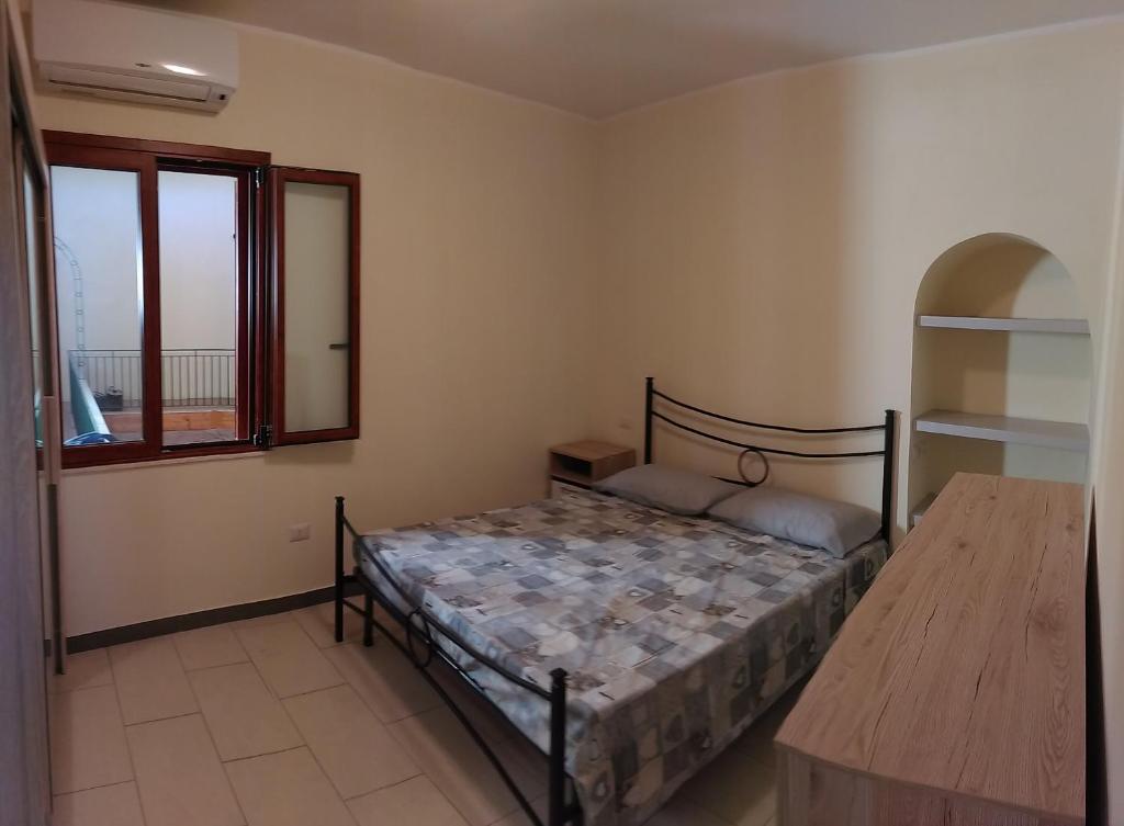 a bedroom with a bed and a window at Domus Incani in Villasimius