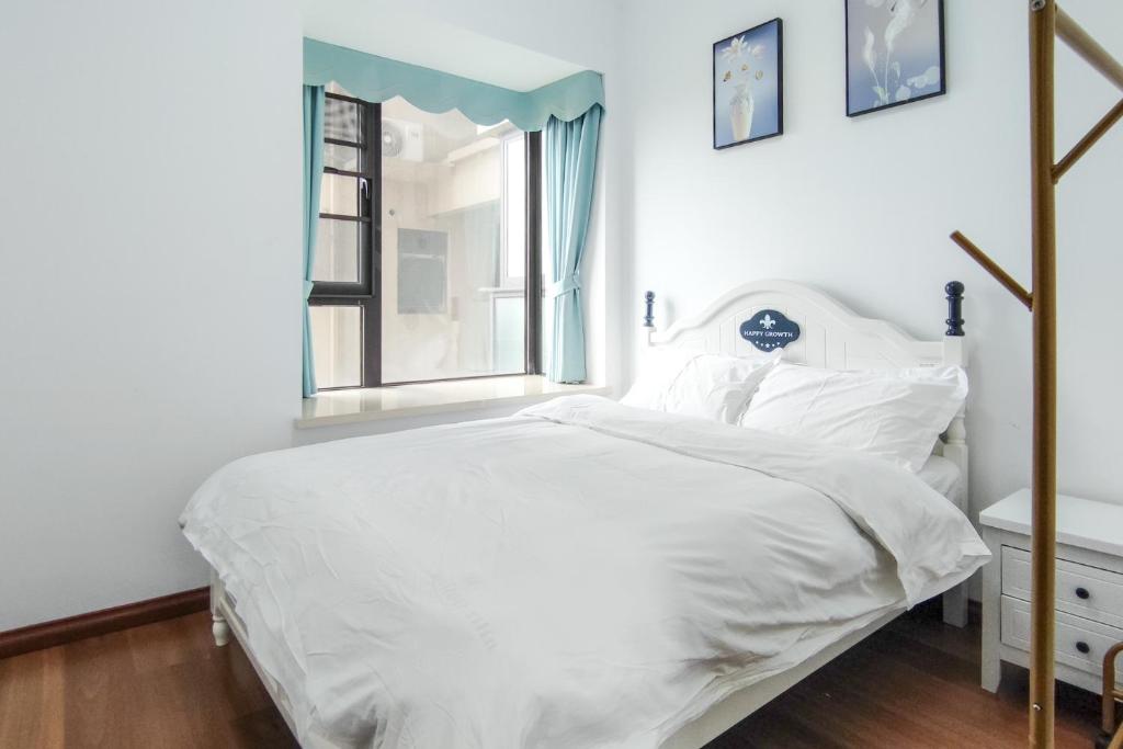 a white bedroom with a bed and a window at WeChat user-s store in Gongche