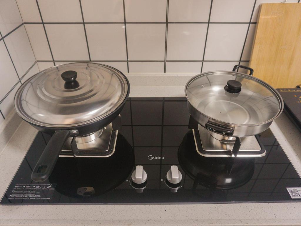 two pots and pans on a stove in a kitchen at Luke Cloud 4G6Y store in Gongche
