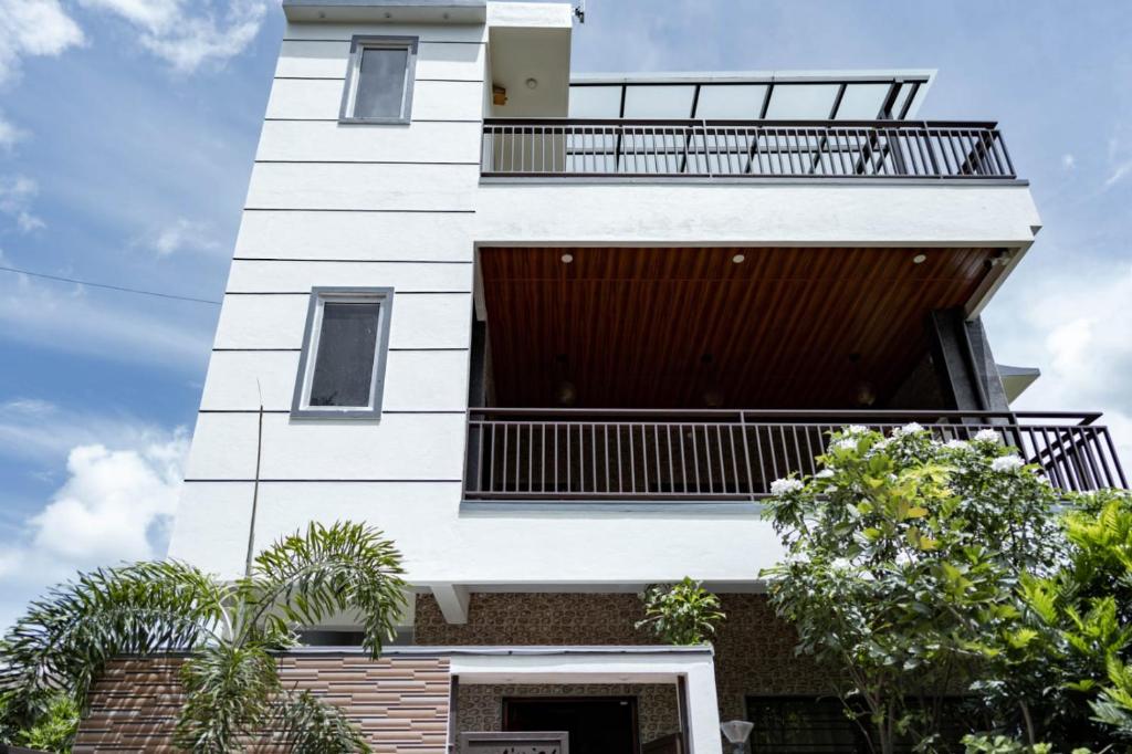 a white building with a balcony on top of it at Hills Pride in Nandi