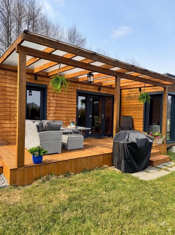 a wooden deck with a pergola on a house at Domki La Bella 3 in Aleksandria