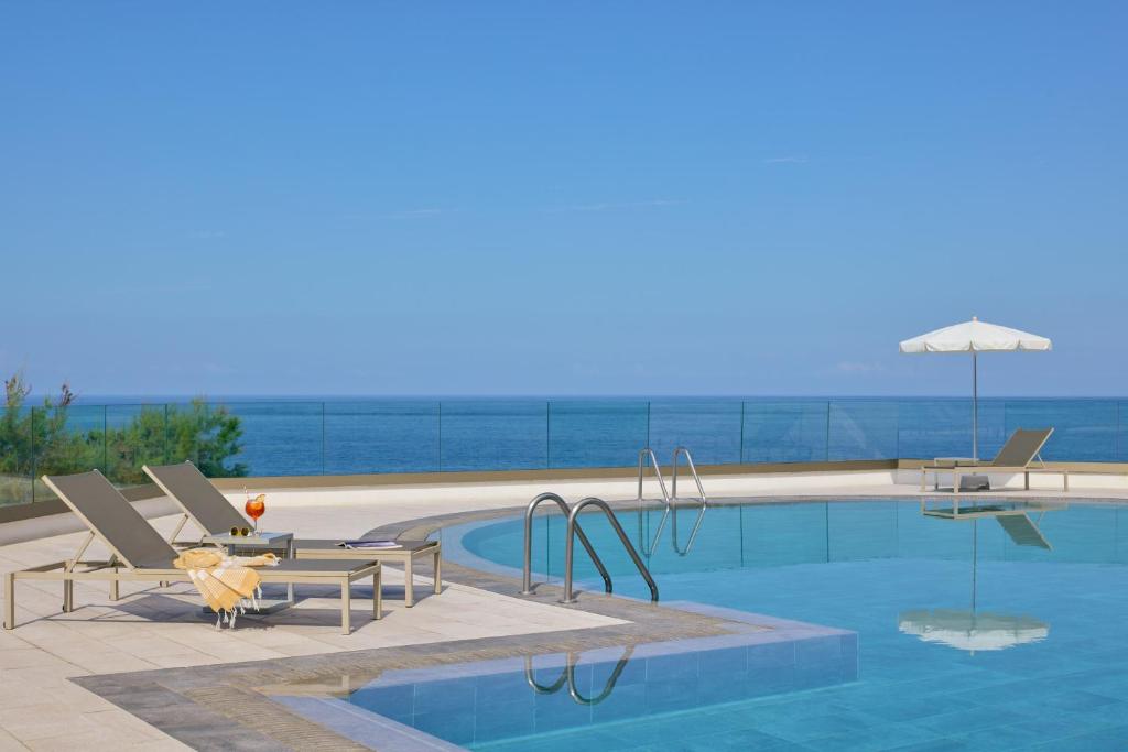 a pool with two chairs and a table and an umbrella at Meliá La Palma in Puerto Naos