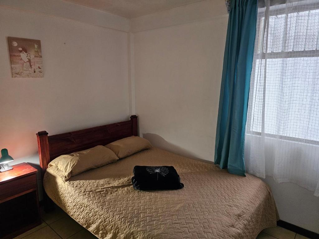 a bedroom with a bed with a bag on it at Apartamento 2 TEC in Cartago