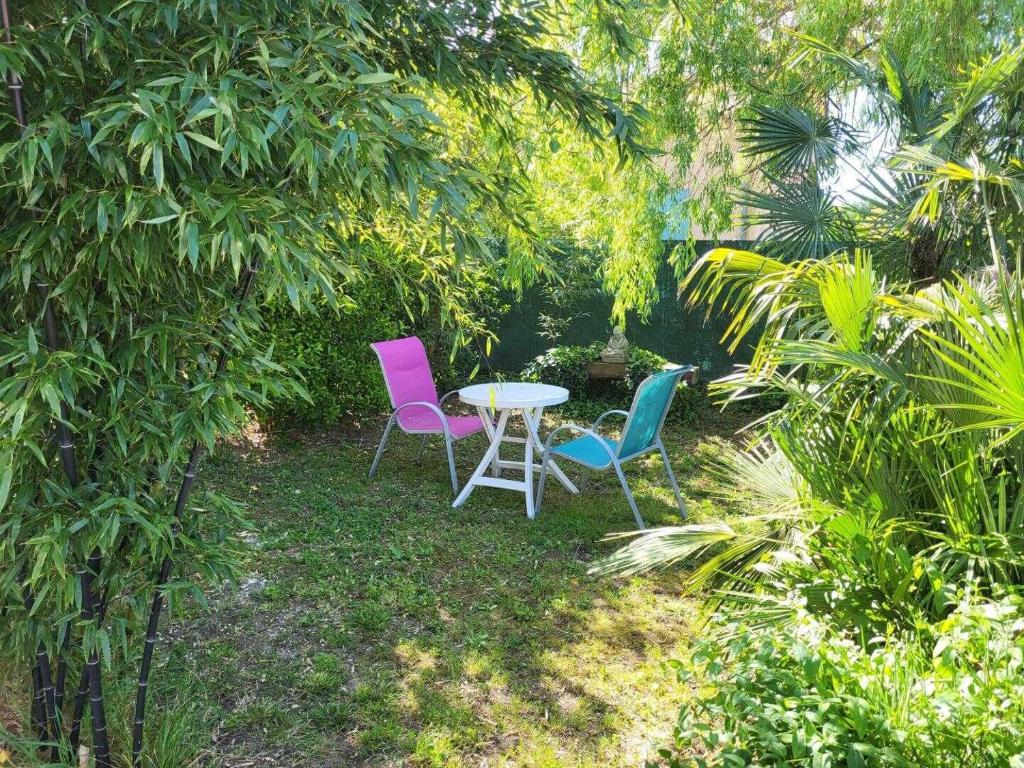 two chairs and a table in a garden at Maison venitia t2 in Aussonne