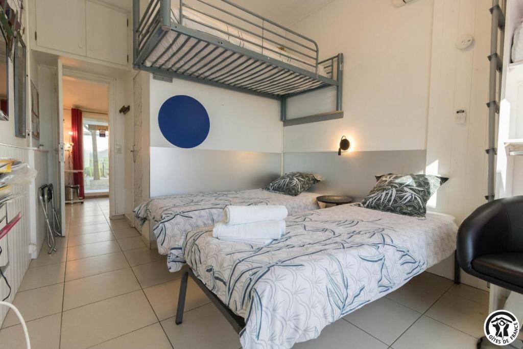 a bedroom with two beds and a chair at Maison venitia t1 in Aussonne