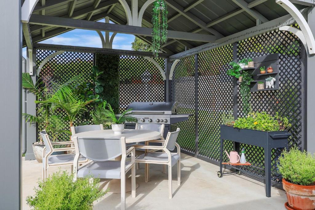 a pergola with a table and chairs on a patio at Jimley Cottage in Warrnambool