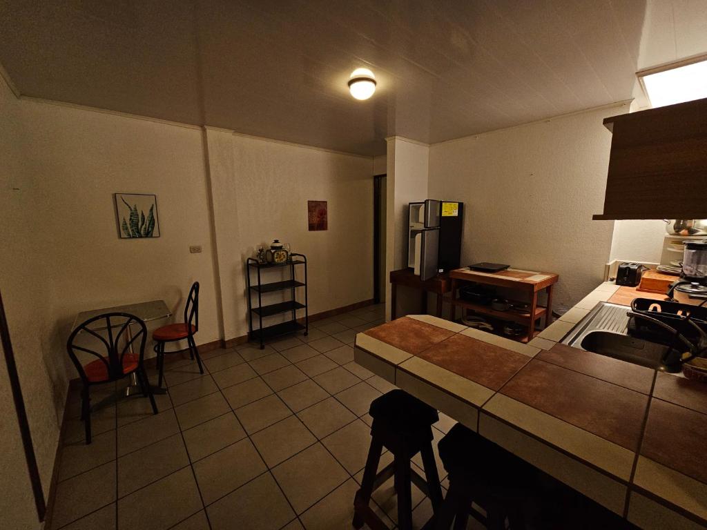 a kitchen with a counter and a table and chairs at Apartamento 3 TEC in Cartago