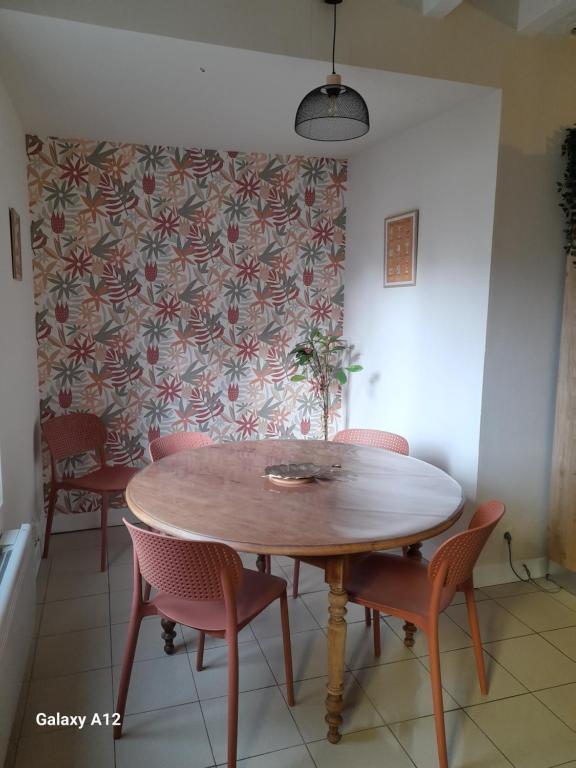 a dining room with a wooden table and chairs at Maison centre ville Bourgueil in Bourgueil