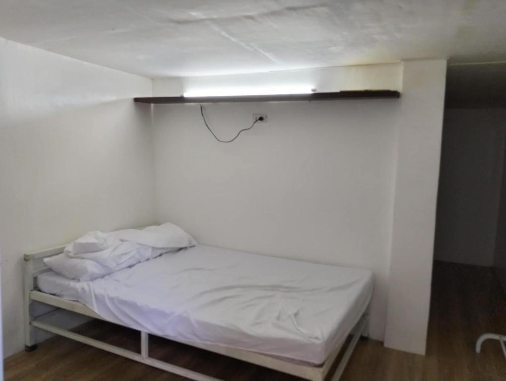 a small bed in a room with a white wall at MGS viewdeck resort in Samal