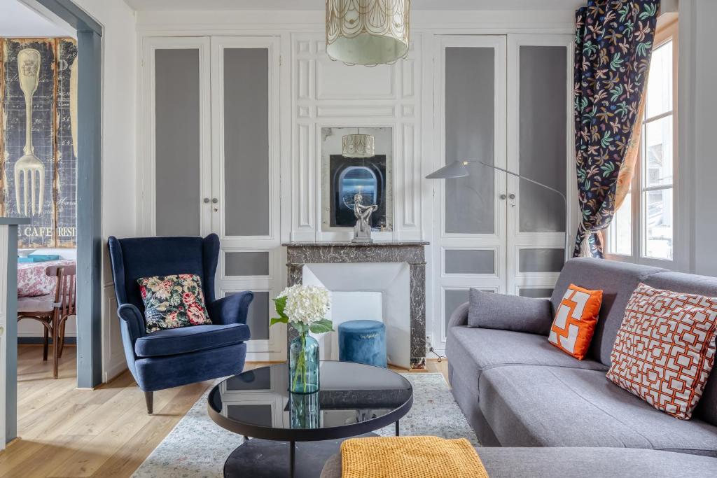 a living room with a couch and a fireplace at TOWNHOUSE TROUVILLE - Appart'Hotel & Spa in Trouville-sur-Mer