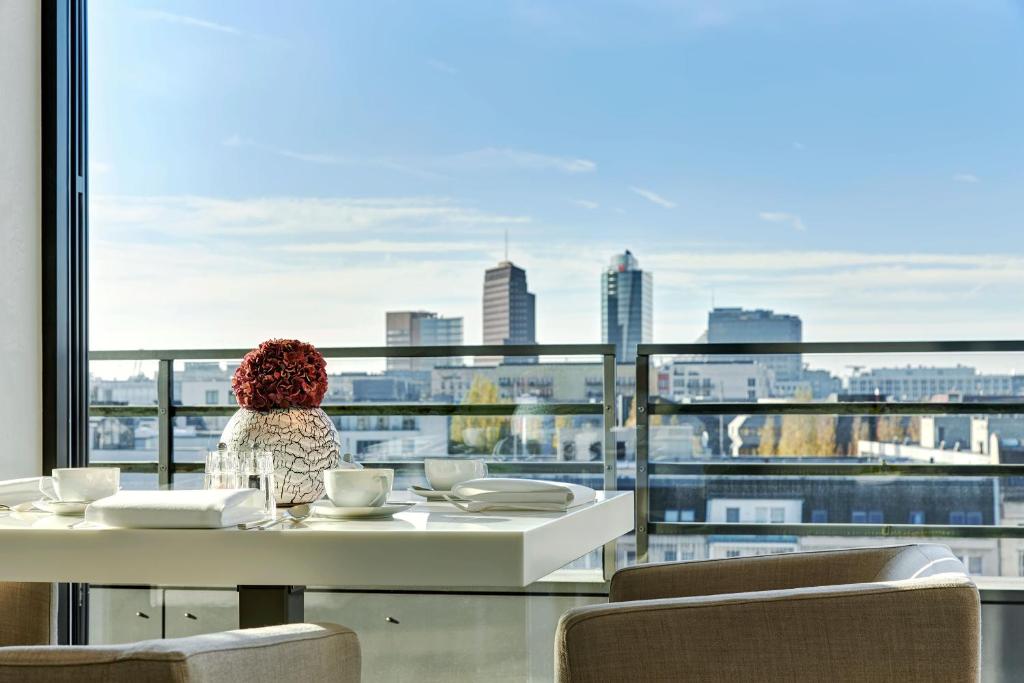 Zimmer mit einem Tisch und Stadtblick in der Unterkunft The Mandala Suites in Berlin