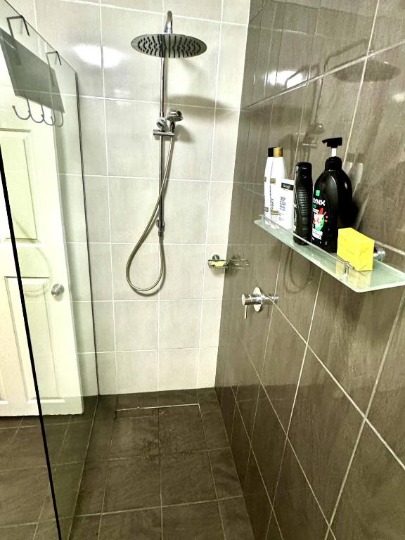 a bathroom with a shower with a shower head at Backpacker Bunks and Queen Pool Clifton Beach in Clifton Beach