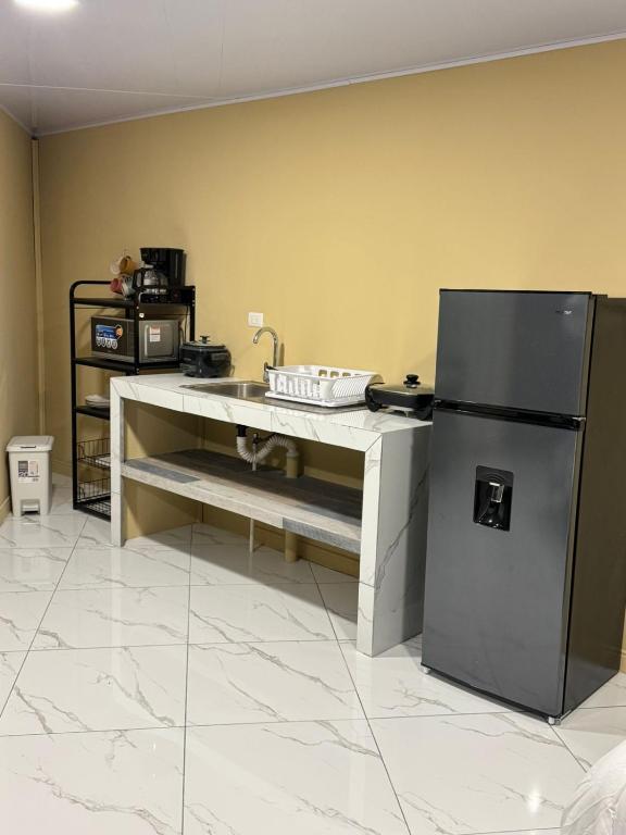 a kitchen with a sink and a refrigerator at Alojamiento Golfito in Golfito