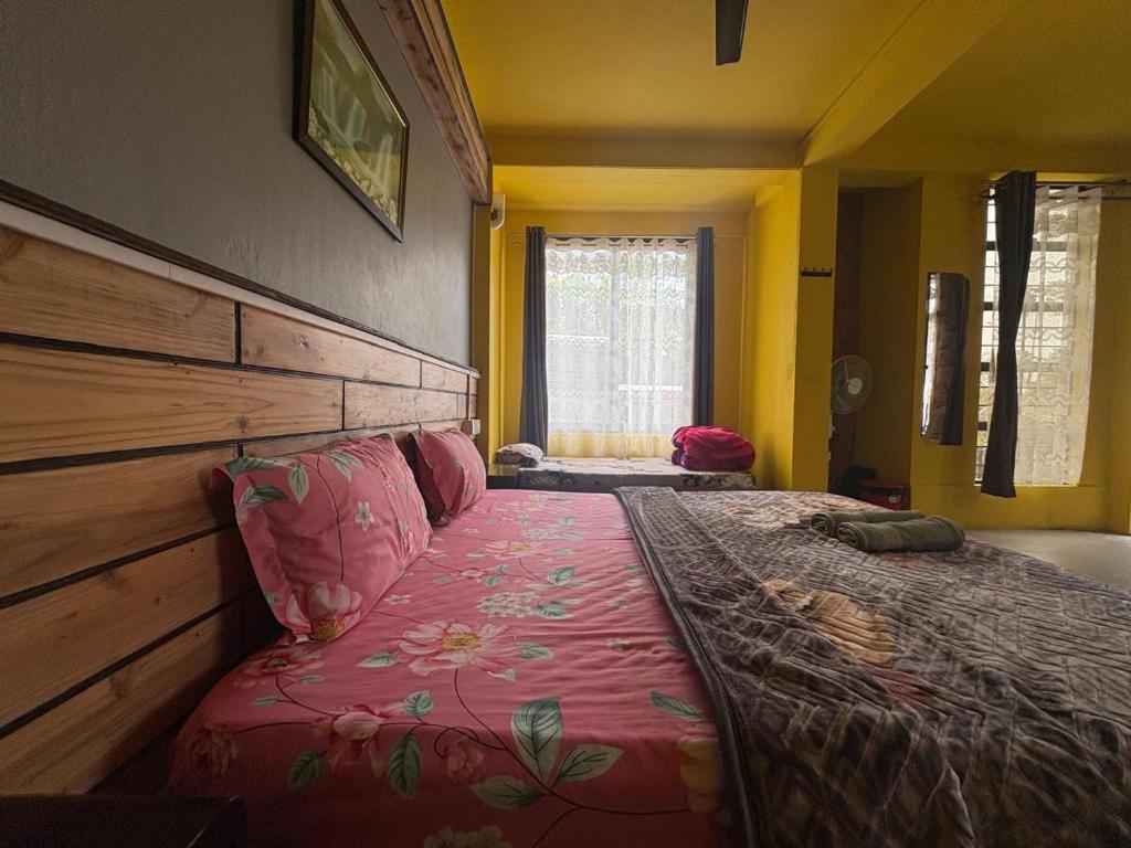 a bedroom with a large bed with a wooden headboard at West corner homestay in Shillong