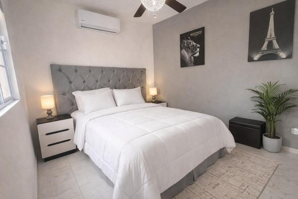 a bedroom with a bed with a white blanket and the eiffel tower at Private Apartment in Prague Poniente Area in Hermosillo