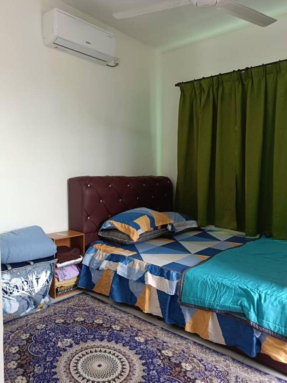 a bedroom with a bed and green curtains at All Rushd Private Pool Homestay in Sungai Besar