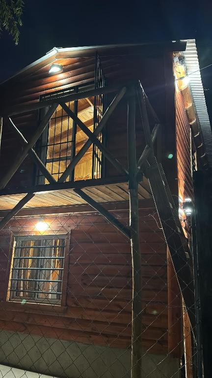 a wooden building with a balcony on the side of it at La cabaña de Noe in San Clemente del Tuyú