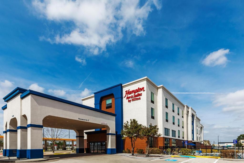 a white and blue building with a parking garage at Hampton Inn & Suites by Hilton Tomball Houston NW in Tomball