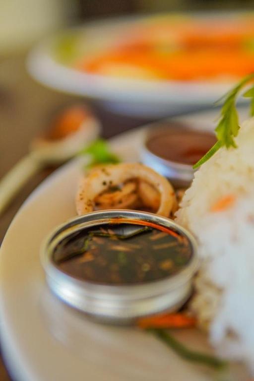 a plate of food with dipping sauce and onion rings at Summit resort in Balangoda