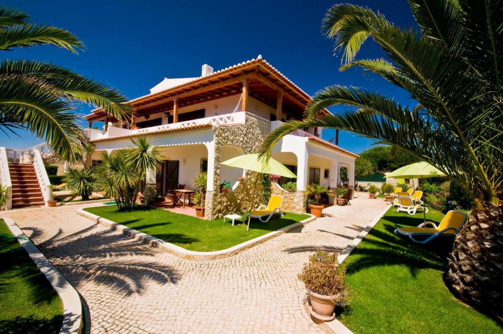 uma villa com um jardim e palmeiras em Residencia Julio em Sagres