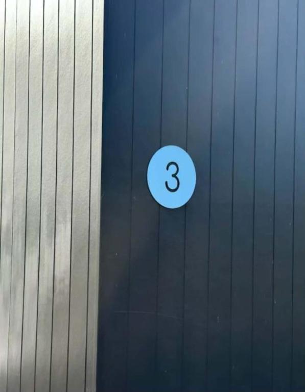 a number three sign on the side of a wall at Swansea Cabins in Swansea