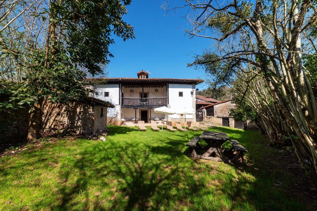 a large white house in the middle of a yard at La Quintana de Los Valles in Benia de Onís