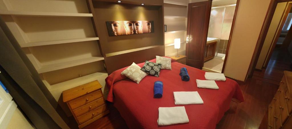 a bedroom with a red bed and a mirror at Zen Apartment Gran Canaria in Las Palmas de Gran Canaria