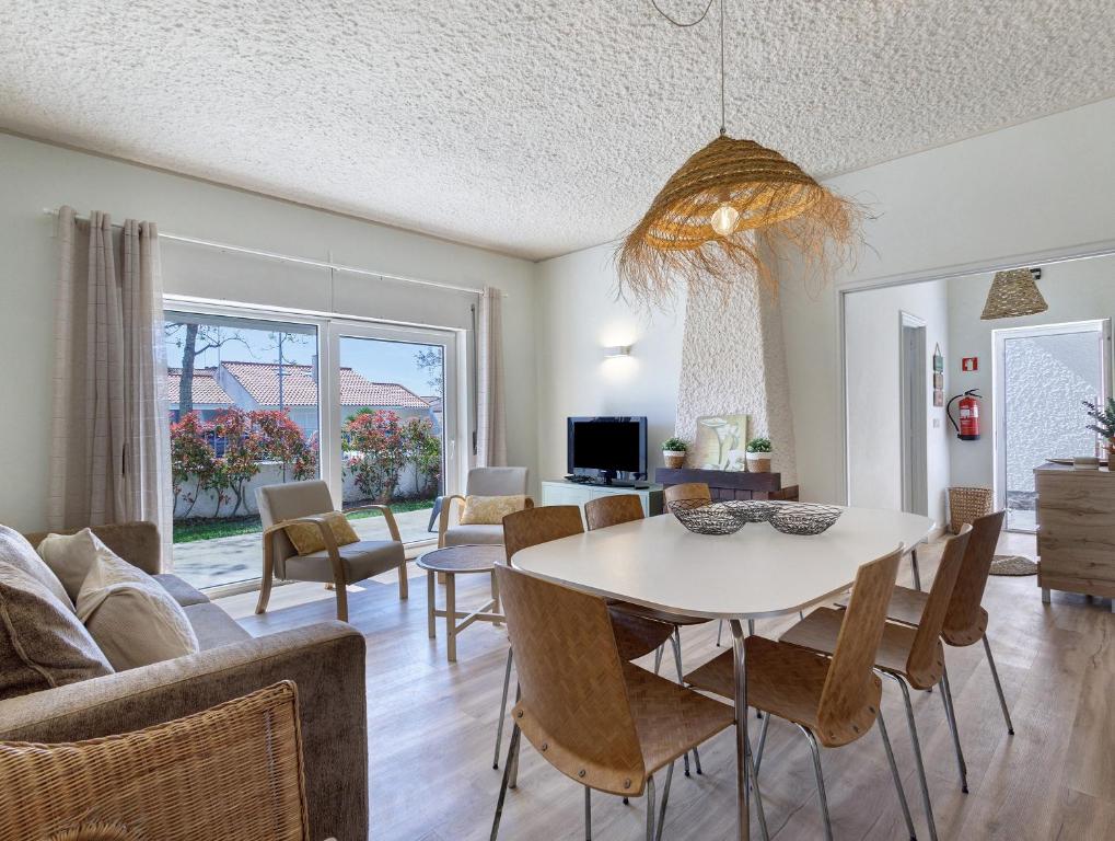 a dining room and living room with a table and chairs at Villa 32 - Villa With Garden in Esposende