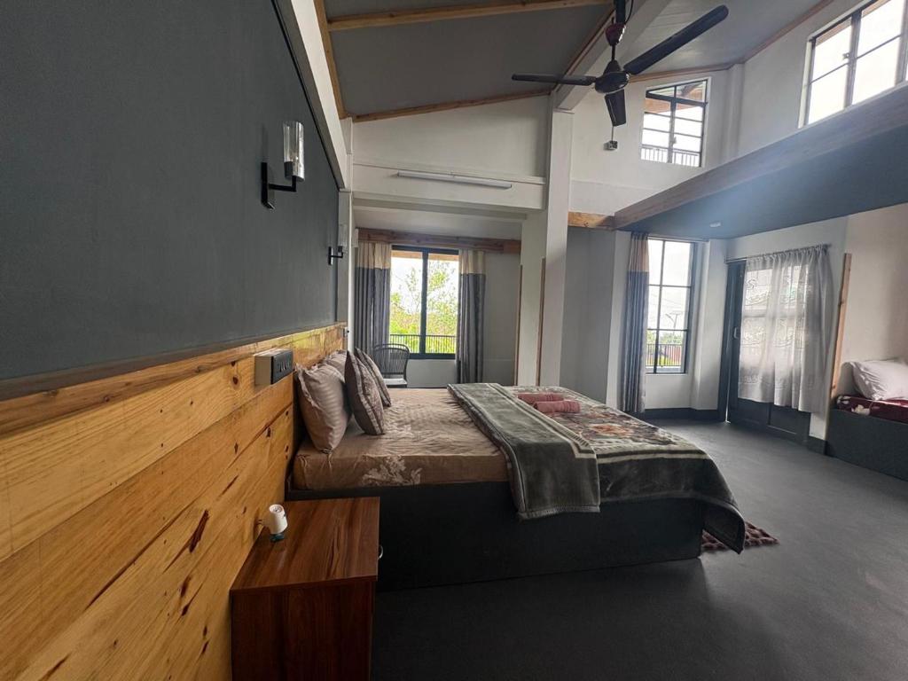 a bedroom with a large bed in a room with windows at West corner B Homestay in Mawlynnong