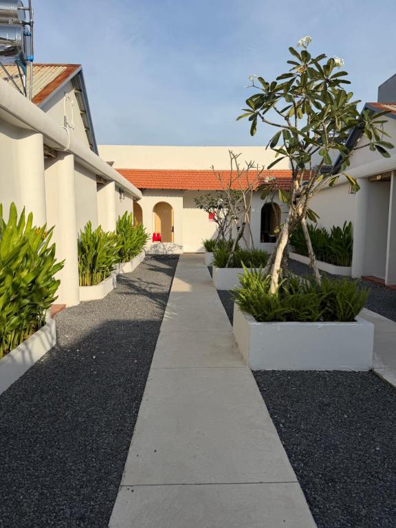 a sidewalk in front of a building with a tree at The Moon Hotel in Chánh Long