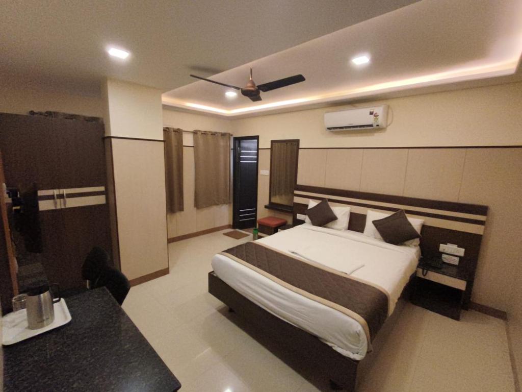 a hotel room with a bed and a desk at Anand Regency Majestic in Bangalore