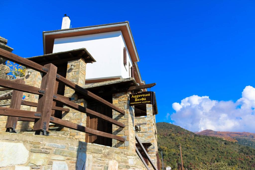 un cartel en un edificio con montañas en el fondo en Archontiko Xantha, en Makrinitsa