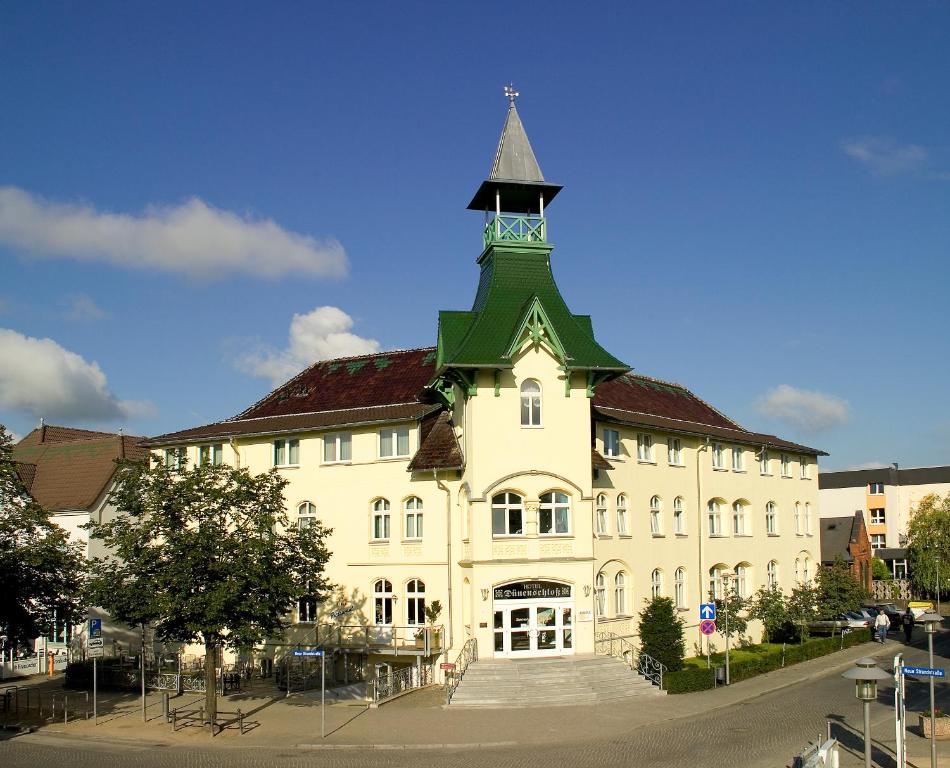 un grand bâtiment avec une tour en haut dans l'établissement Hotel Dünenschloß, à Zinnowitz