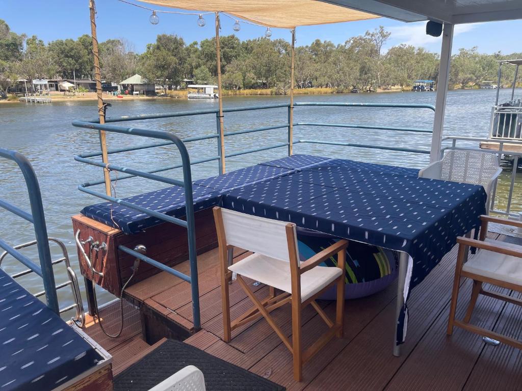 a table and chairs on the deck of a boat at Mandurah Houseboat Just Chillin in Mandurah
