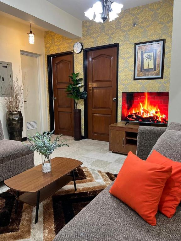 a living room with a fire fireplace in the wall at The Orange Nook - Davao in Davao City