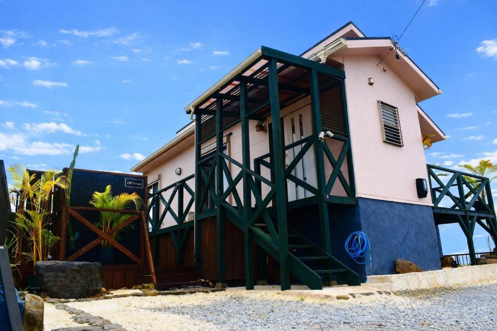 a house with a green and white building at 118 Terrace in Nakijin