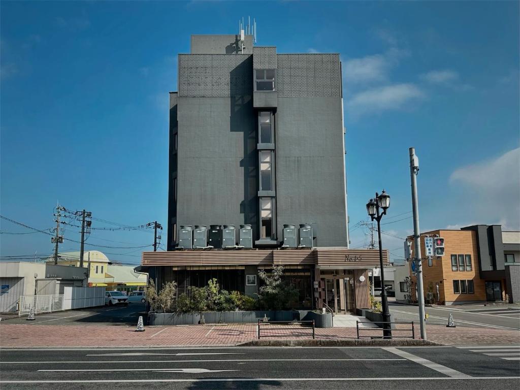 ein hohes Gebäude an einer Stadtstraße mit einer Straßenlaterne in der Unterkunft Hotel Sun Road in Amakusa