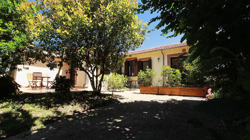 a house with a tree in front of it at Gite La Chartreuse du Canal du Midi in Toulouse