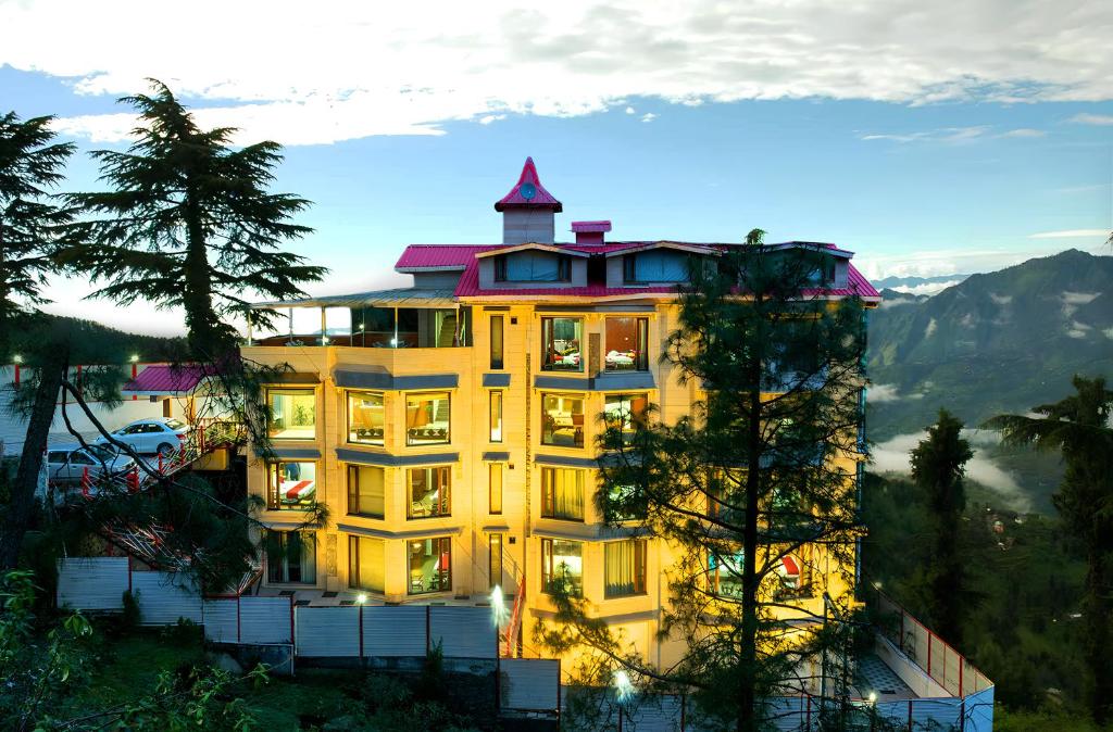 a large building with a tower on top of it at Rock Castle By DLS Hotels in Shimla