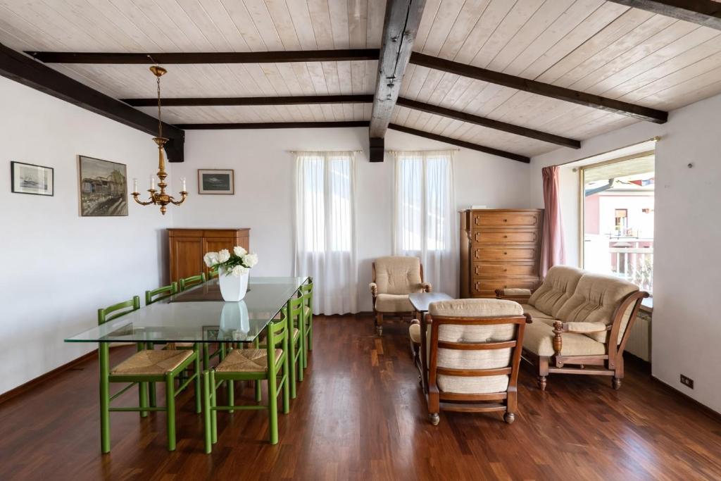 a dining room with a green table and chairs at Attico Zamagna in Cesenatico