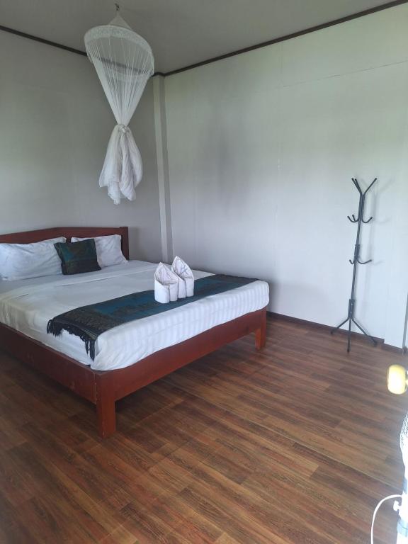a bedroom with a bed with two towels on it at champa resort in Don Det