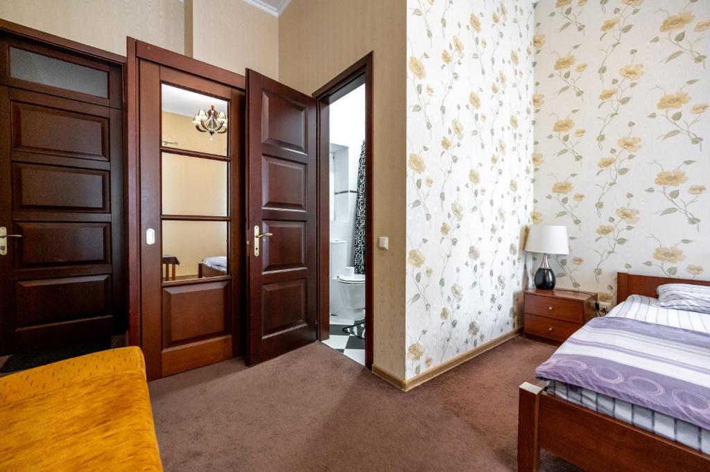 a bedroom with a bed and a door leading to a bathroom at Hotel European 8 in Odesa