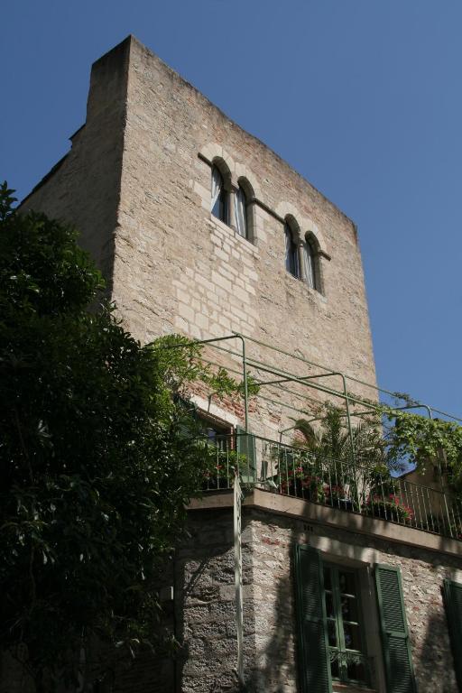 um edifício de tijolos alto com duas janelas e uma varanda em Hôtel Jean XXII em Cahors