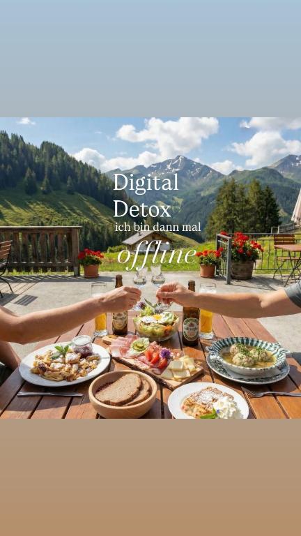 a table full of food with mountains in the background at Alpengasthof Karalm in Rauris