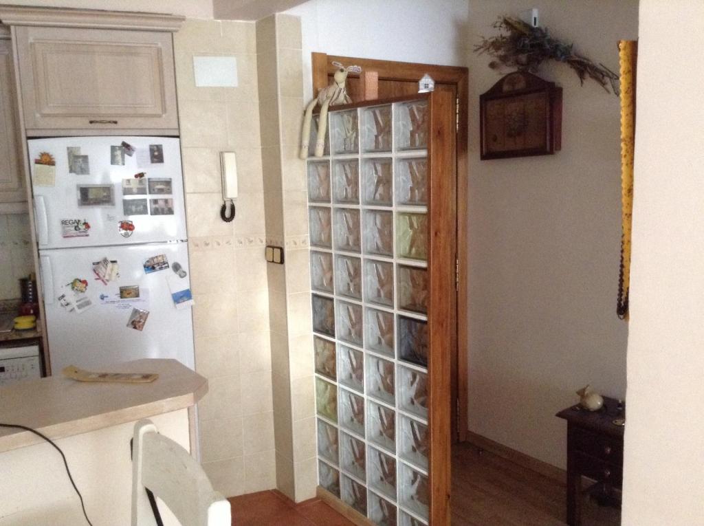 ベトレンにあるTuca d'Aranのガラス張りの壁、冷蔵庫付きのキッチンが備わります。