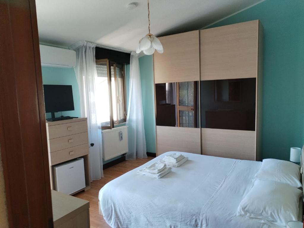 a bedroom with a large white bed and a television at home sweet home in Buia